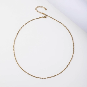 Detailed view of a golden minimalist twisted wave chain necklace with lobster clasp closure