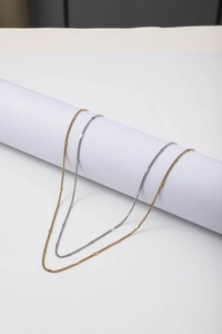 Detail of gold and silver stainless steel cable chains with flat rectangular sequins