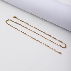 Detail of 18K gold wave chain necklace featuring a lobster clasp and extension link