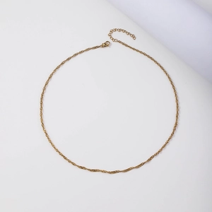 Macro detail of 18K gold water wave chain featuring lobster clasp and extension link
