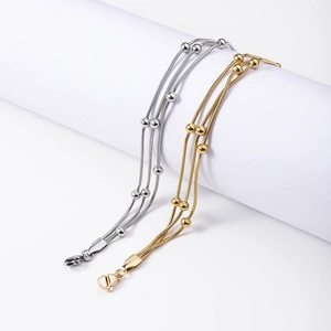 Detailed view of triple-layered snake chains with gold and silver bead accents