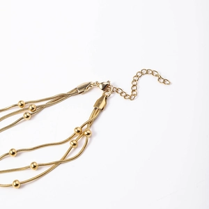 Detail of multi-layer snake chain bracelet with gold beads and lobster clasp closure