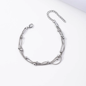 Detail of silver triple-layered snake chain bracelet with smooth metal beads and lobster clasp