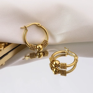 Detailaufnahme der 18K vergoldeten Creolen mit zentraler Perle und gedrehtem Metalldraht-Design