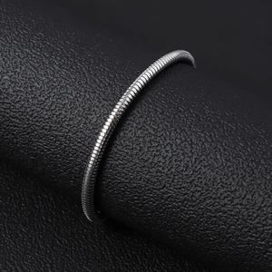 Minimalistisches Schlangenarmband aus silbernem Edelstahl auf schwarzem Hintergrund