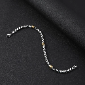 Detailed close-up of a square box chain bracelet with gold-tone textured beads and lobster clasp