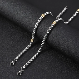 Detail of 5mm stainless steel box chain necklace with gold ring accents and lobster clasp