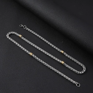 Détail du collier chaîne épi de 5 mm en acier inoxydable avec des accents dorés sur cuir