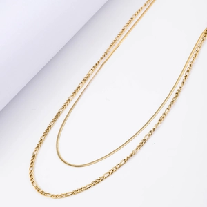 Close-up of double layered 18K gold plated necklace with snake and figaro chain details