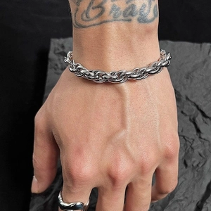 Herren-Panzerarmband aus Edelstahl im industriellen Webdesign auf dunklem Stein