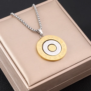Dettaglio del ciondolo rotante zodiaco oro e argento con simbolo Bagua e catena