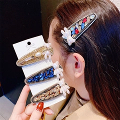 Détail de pinces à cheveux gouttes avec strass, perles et petits animaux en résine