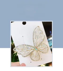 Macro detail of white crystal zircon butterfly hair clip with gold metal spring claw