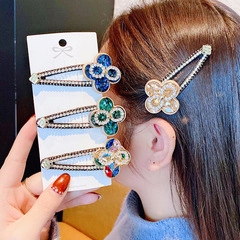 Détail macro de barrettes trèfle en strass multicolores avec bordures métalliques