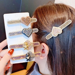 Détail d'un ensemble de 5 barrettes en strass avec motifs de cœur et d'oursons