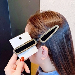 Détail de barrettes rétro en velours noir avec bordures scintillantes en strass sur clips