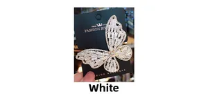 Macro detail of white crystal zircon butterfly hair clip with shimmering gold finish