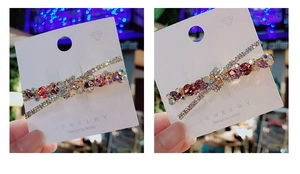 Vista dettagliata del fermaglio coreano a forma di X con strass multicolori scintillanti