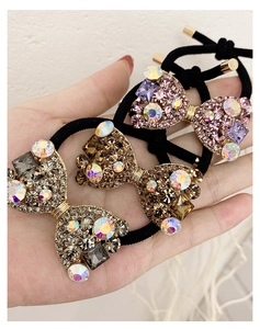 Détail de chouchous nœuds scintillants orné de strass colorés champagne et roses