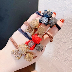 Detail of multi-color high-elastic hair ties with crystal-set golden tiger and bear charms