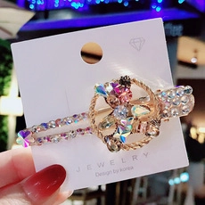 Close-up of golden star hair clip with colorful rhinestones on jewelry card