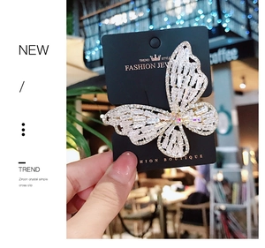 Detailed close-up of butterfly hair clip with shimmering white zircon crystal pavé setting