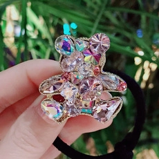 Close-up of bear-shaped hair tie with sparkling pink and purple crystals