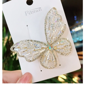 Close-up of white butterfly hair clip with clear cubic zirconia crystals and metal finish