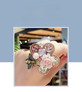 Detailed shot of Baroque pearl hair tie with rhinestones, flowers and a bee charm