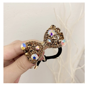 Détail du chouchou nœud doré luxueux avec des strass champagne et des cristaux