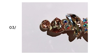 Macro shot of 3D crystal butterfly hair clip with gold base and colorful rhinestones