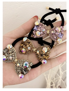 Gros plan sur des chouchous nœuds en strass brillants dorés, roses et noirs