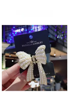 Primo piano dettagliato di un fermaglio per capelli a fiocco con perle e base oro
