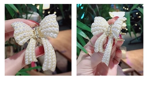 Dettaglio di un fermaglio per capelli a fiocco con perle e base in metallo dorato