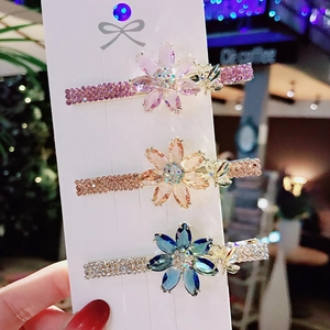 Lot de trois barrettes à fleurs en zircons aux couleurs lavande, champagne et bleu marine