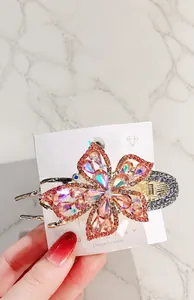 Close-up of pink crystal flower hair claw clip with golden alloy base and rhinestones