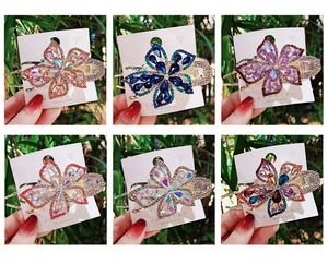 Detailed view of large rhinestone flower hair clips in six vibrant assorted colors