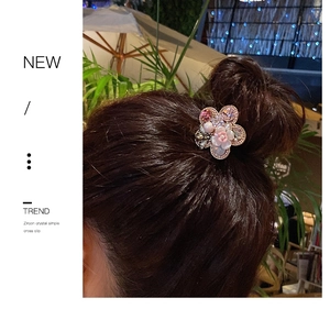 Close-up of hair clip with five-petal flower design, zircon crystal and baroque pearl