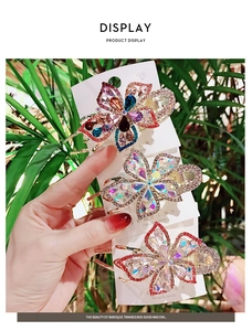 Close-up of hand-held floral hair clips with colorful rhinestones and alloy details