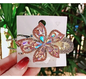 Close-up of pink crystal flower hair claw clip with rhinestones on display card