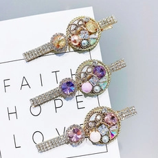 Detail of three rhinestone duckbill clips with pearls and crystals on display cards