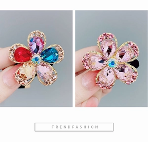 Macro di elastico per capelli con fiori di cristallo colorati, bordi dorati e strass lucidi