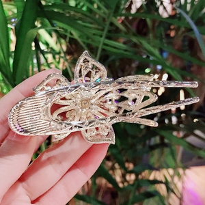 Golden floral hair claw clip with purple rhinestones and intricate hollow design
