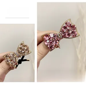 Detailed close-up of glittering rhinestone bow hair ties in pink and champagne colors