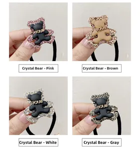 Detail showing four crystal-encrusted bear hair ties in pink, brown, white, and grey colors
