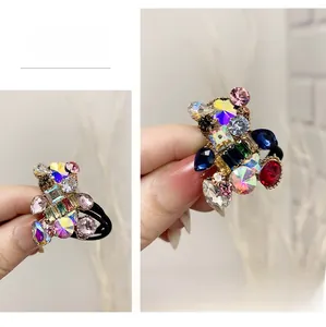 Detailed shot of handmade bear hair tie featuring colorful rhinestones and black elastic
