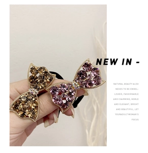 Detail of elegant bow hair ties with sparkling brown and purple rhinestone crystals