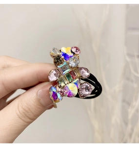 Close-up of black elastic hair tie featuring a cute bear shape with colorful crystal rhinestones