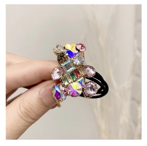 Close-up of cute bear hair tie with colorful crystal rhinestones and elastic black band