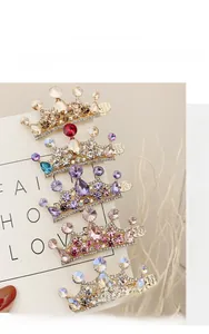 Dettaglio ravvicinato di fermagli a corona con strass colorati e base in metallo inciso